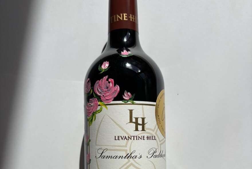 Bottle of red wine with hand-painted flowers.