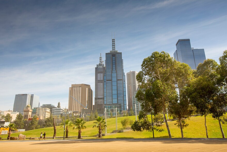 Trees, grass and city buildings at at Birrarung Marr park.