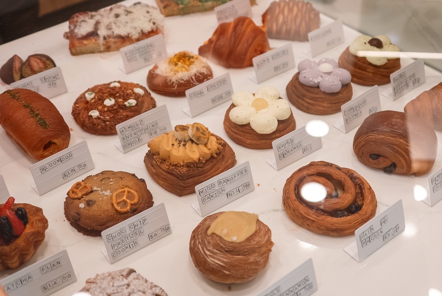 Japandi pastries with different toppings and shapes lined up in a row with description notes.