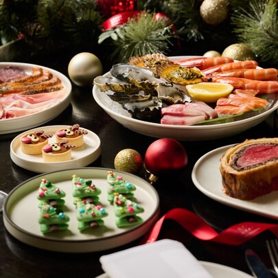 A colourful display of festive fare including Christmas tree cookies, Beef Wellington and champagne glasses.