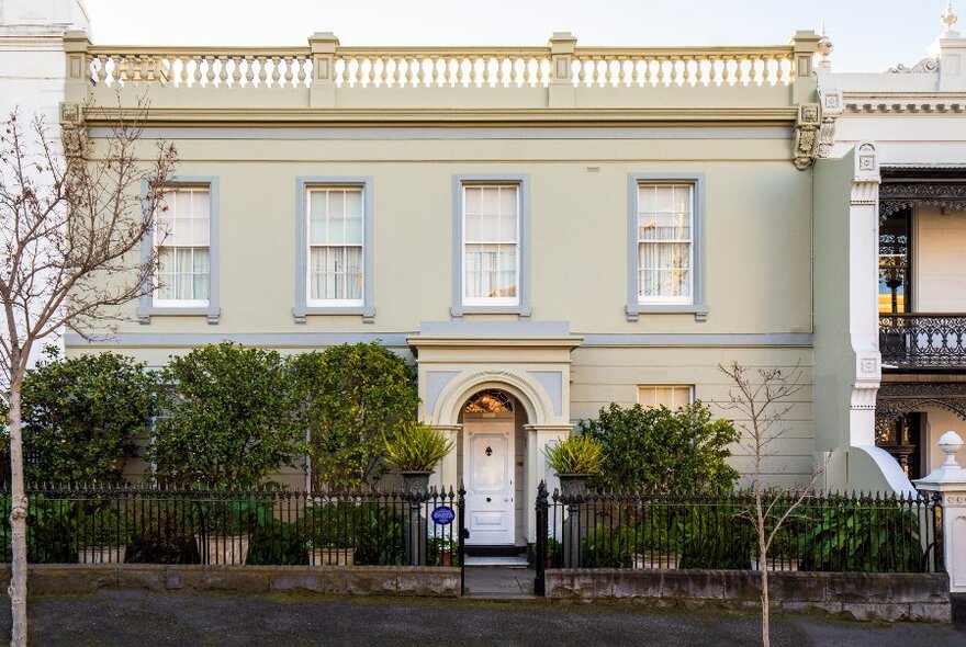 The two-storey Georgian building facade of The Johnston Collection house museum, with small trees in the front garden.