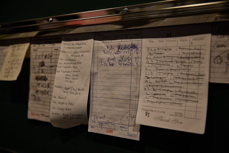 Kitchen dockets lined up in a row in a restaurant kitchen.