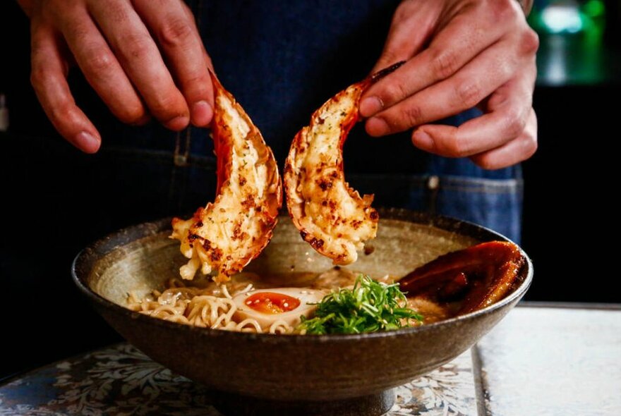 A bowl of soup with lobster tails