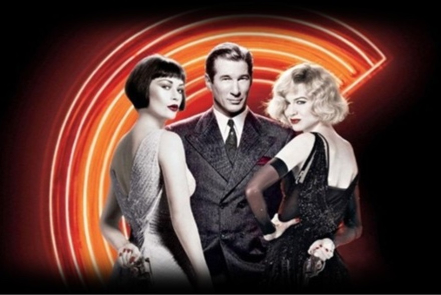 Actors Renee Zellwegger, Catherine Zeta Jones and Richard Gere wearing 1920s outfits in front of a curved neon sign.