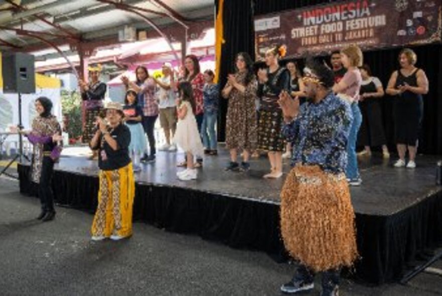 A cultural performance with dancers, musicians and people on a stage at the Indonesian Street Food Festival at Queen Victoria Market.