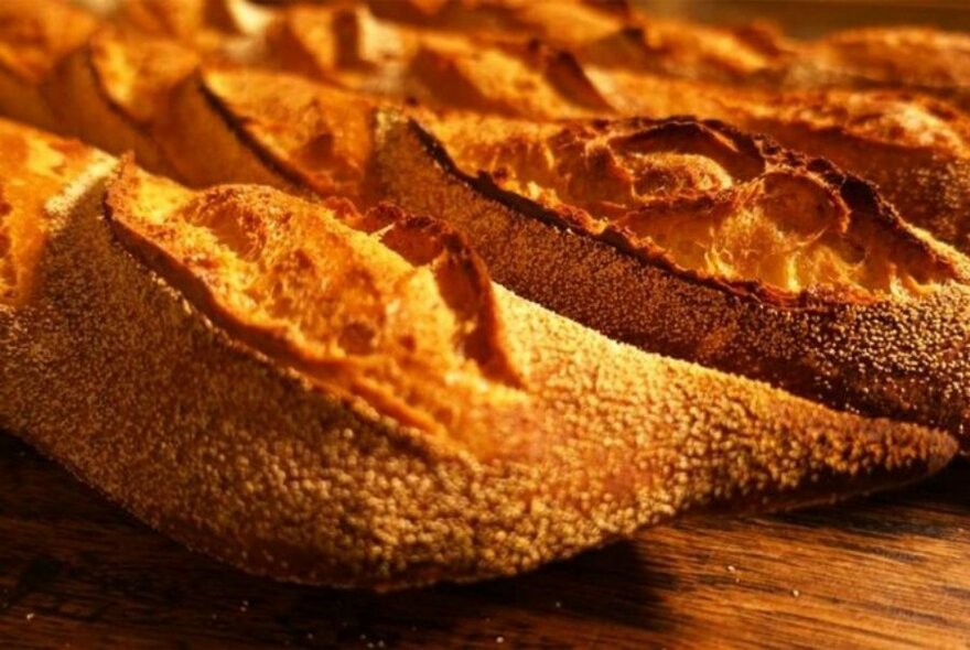 Crusty baguette style bread on a wooden board.