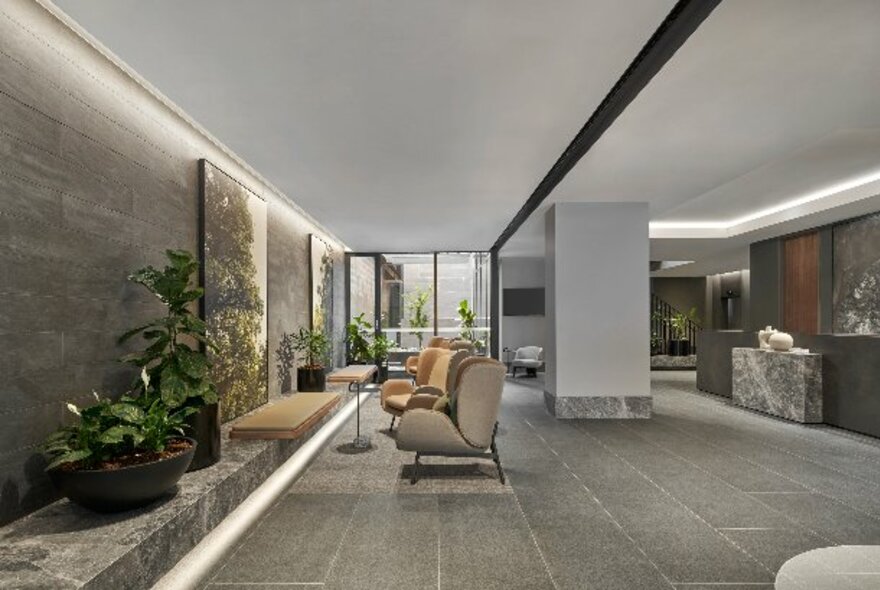 The foyer of the Courtyard Melbourne hotel with cosy arm chairs, indoor plants and reception.