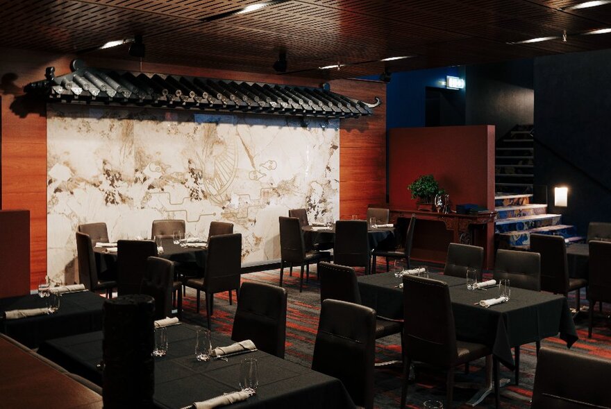 Dark tables and chairs in a formal dining space with Asian roof detail.