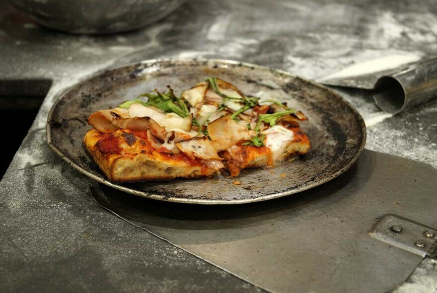 Slice of pizza in a metal pan. 