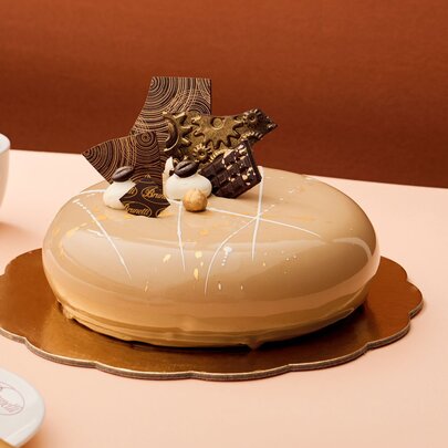 A round cake with chocolate on top.