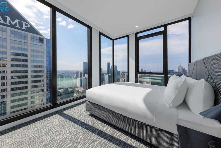 Looking at a hotel bedroom with a vast city view. 