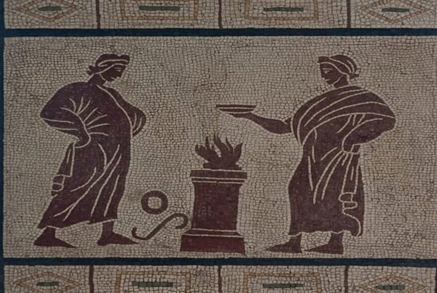 Example of a Roman mosaic with tiles in brown and black, two men wearing robes around a fire.