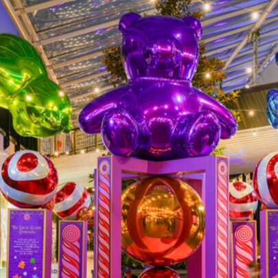 Three large, colourful and shiny gummy bears as part of a Christmas installation inside a shopping mall.