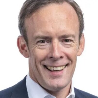 Technology CEO Aidan Tudehope, smiling wearing open-necked shirt and jacket.
