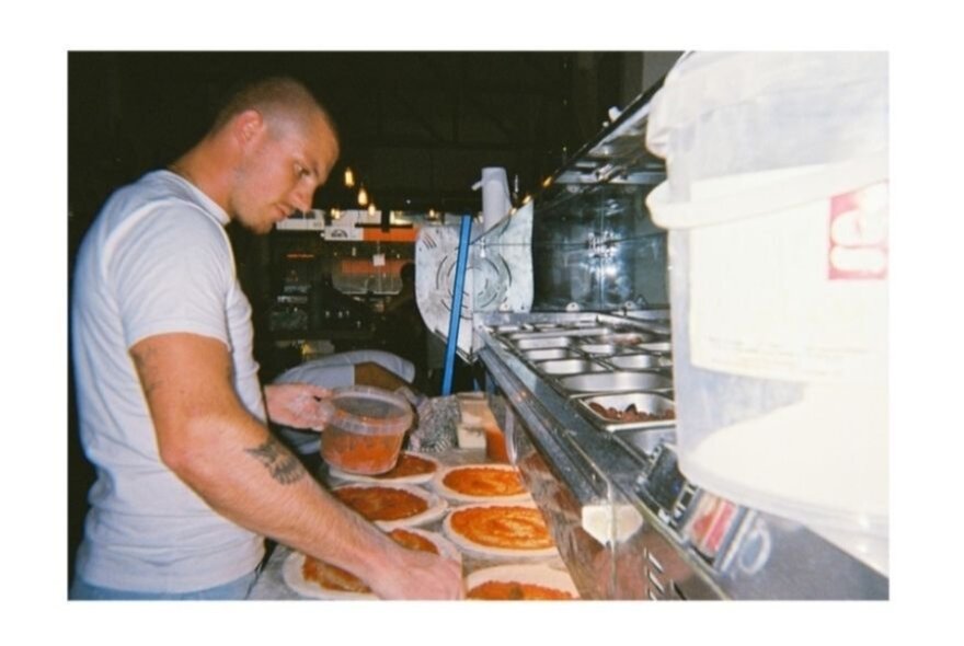 A chef preparing many pizzas.