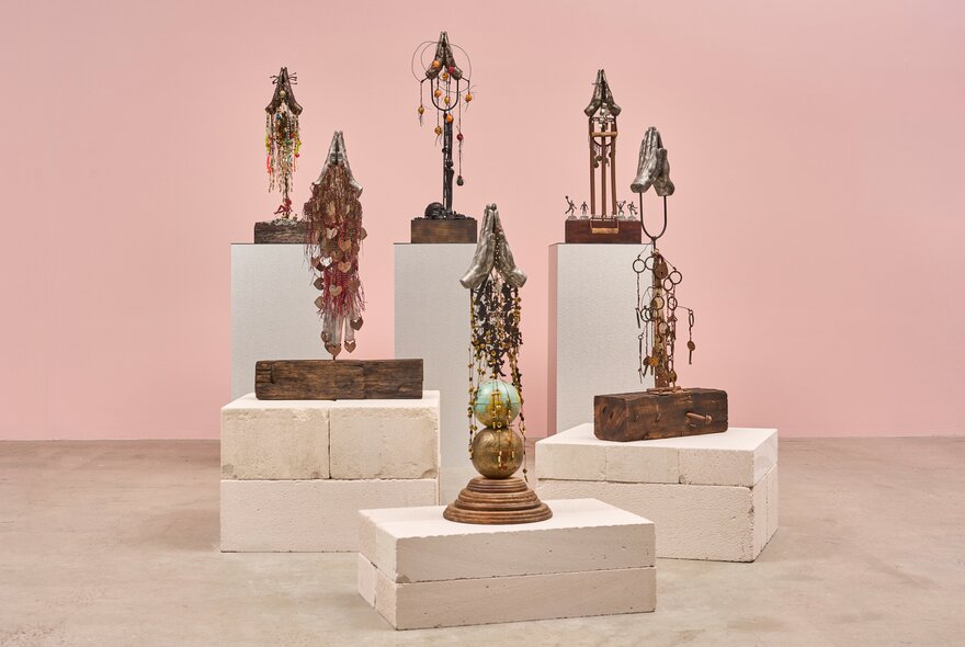 Display of totemic sculptural pieces on plinths in a gallery setting.