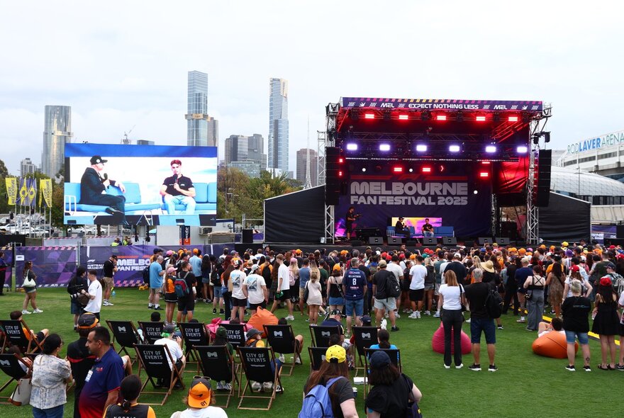 F1 fans at Fed Square with stage and big screen.