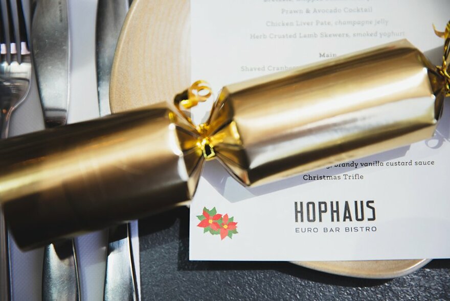 Gold Christmas cracker over a menu.