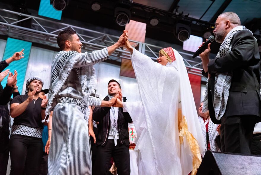 Palestinian performers on stage at Fed Square in traditional clothing.
