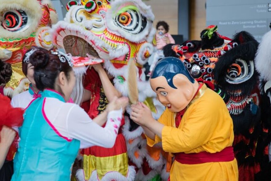 Lunar New Year celebrations with dragons and people wearing masks. 