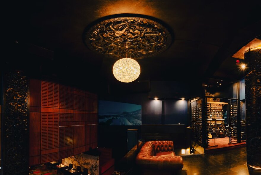 Large ornate lantern lighting in a moodily lit bar with chesterfield sofa and furnishings.