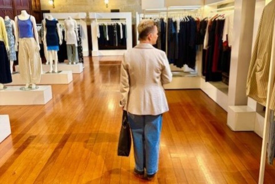 A person walking around inside a store that sells slothes.