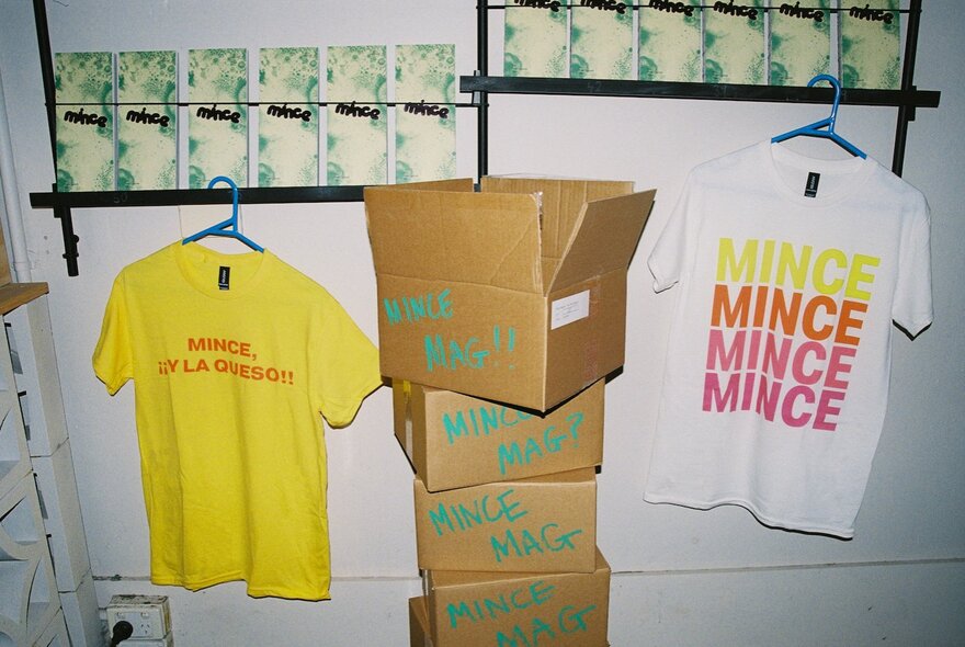 Mince Magazine t-shirt merchandise with a stack of boxes.