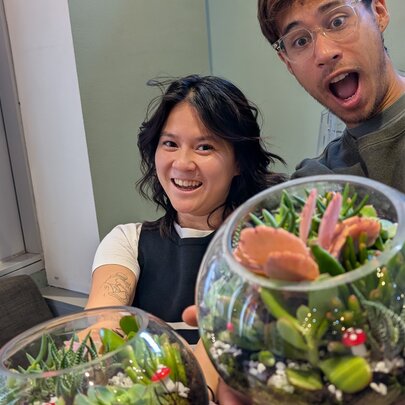 People holding their glass bowl terrariums, looking amazed.
