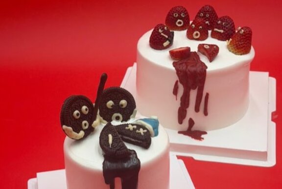 Two cakes with toppings depicting murder scenes.