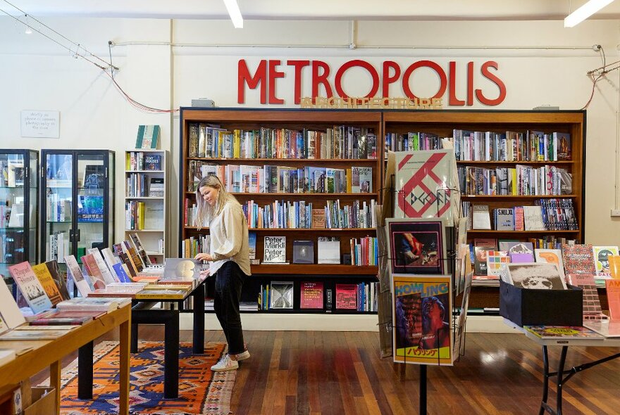 A woman is in a bookshop browsing books