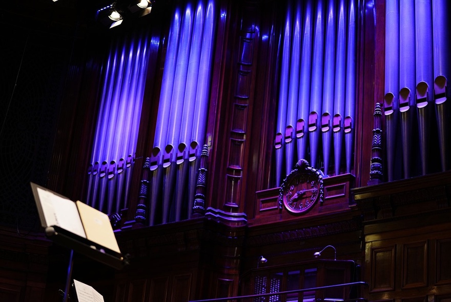 A Grand Organ, illuminated in blue / purple.