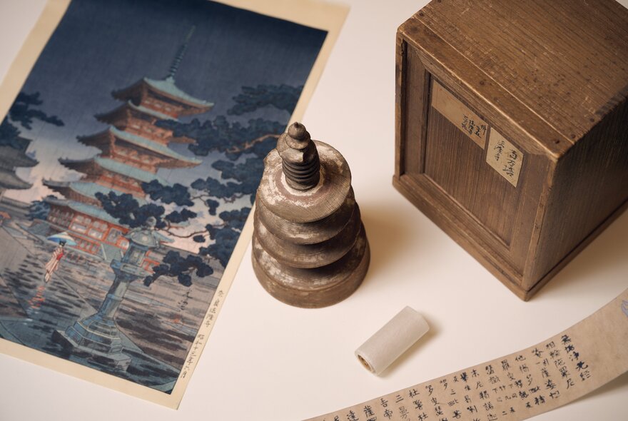 Japanese print of a temple with box, bell and script.