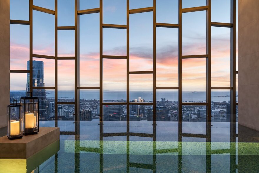 Indoor pool at the Ritz-Carlton Hotel Melbourne, with a view of the city through geometric shaped windows.