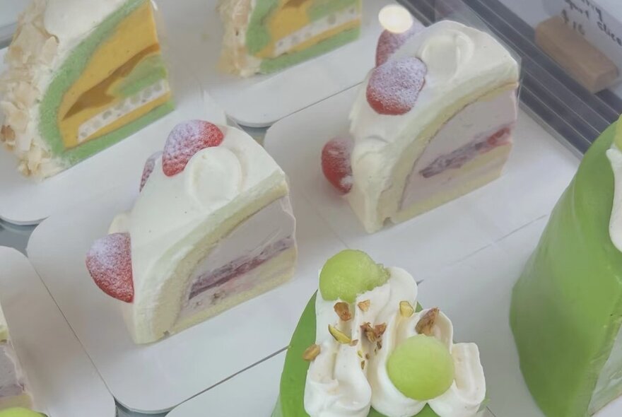 Slices of layered cakes in a display.