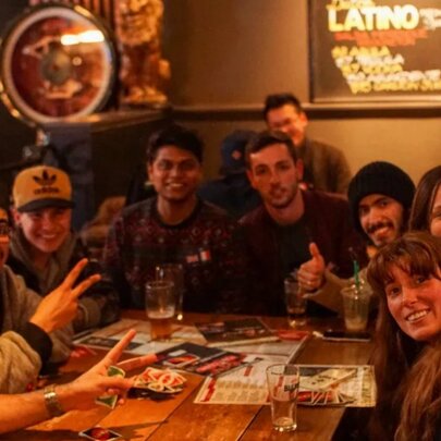 Group of smiling people sitting around a table in a pub.