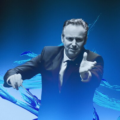 An orchestra conductor with his left arm outstretched in front of him, and holding a baton in his right hand; a swirl of blue as the background.