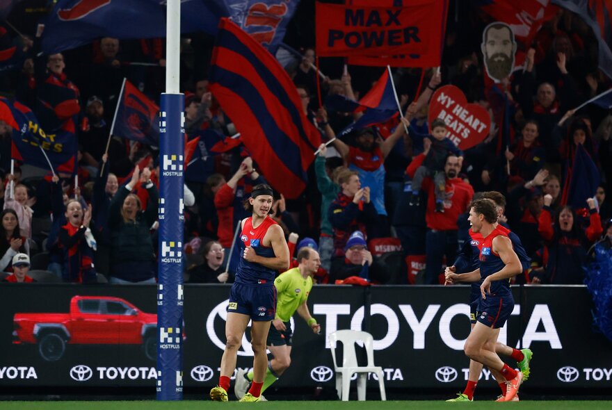 Melbourne AFL football players on the field during a match.