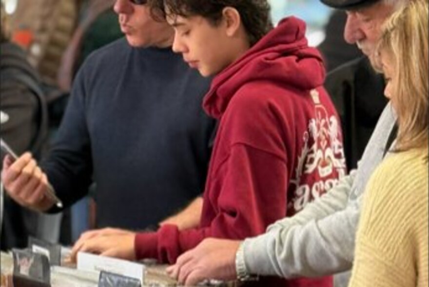 Shoppers flicking through crates of vinyl records at a Record Fair.