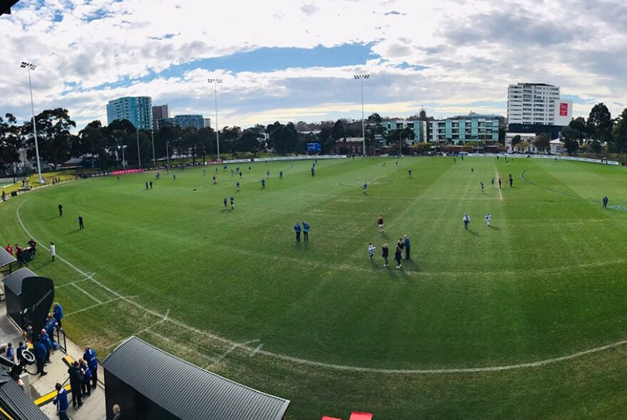 A distorted wide angle lens shot of a football field with players on the grass.