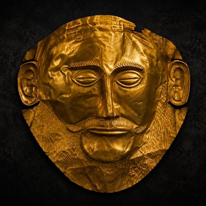 An gold artefact showing a man's face fashioned in gold. 