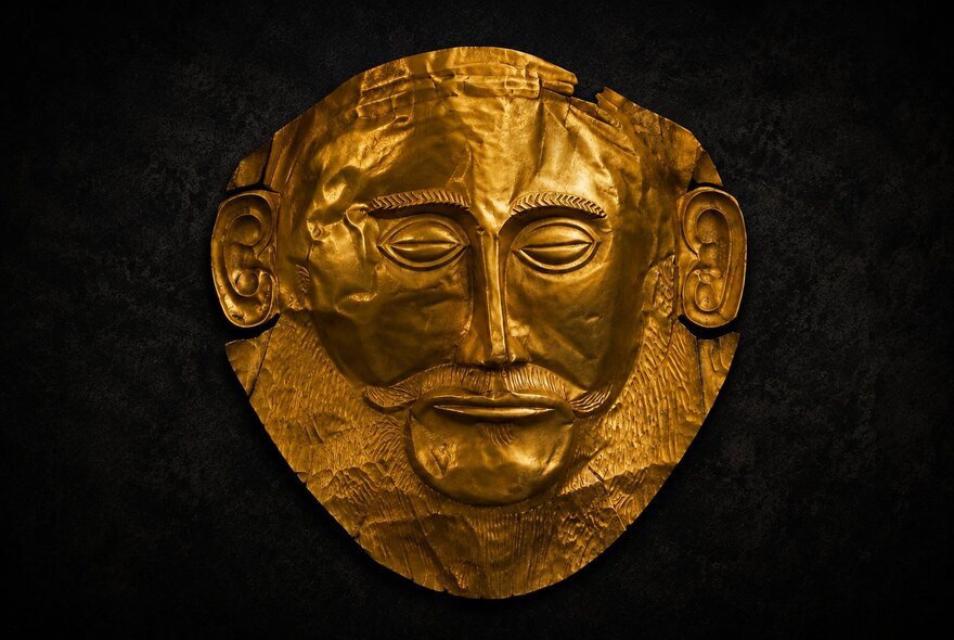 An gold artefact showing a man's face fashioned in gold. 