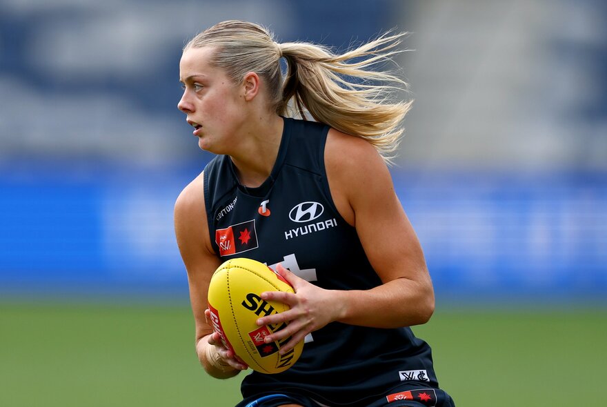 Carton player holding a yellow ball, her ponytail flying.