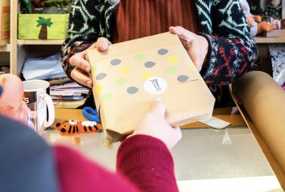 Women handing a gift to someone.