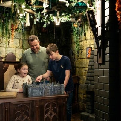 A Dad with tow children playing a game at an escape room.