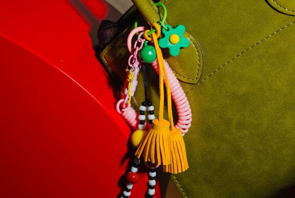 A colourful beaded and tassel charm on a handbag.