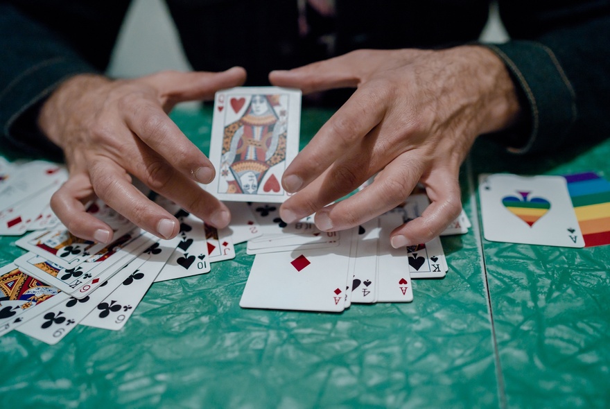 Hands holding playing cards while performing a trick.