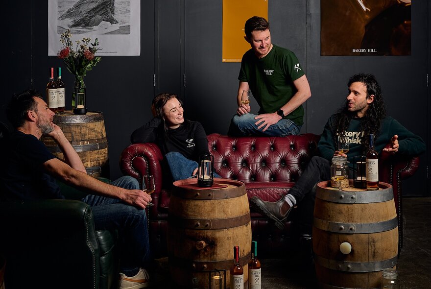People gathered on a couch and armchairs at a distillery taking part in an introductory tasting tour.