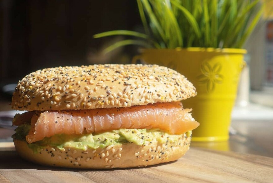 Smoked salmon and avocado bagel with sesame seeds.