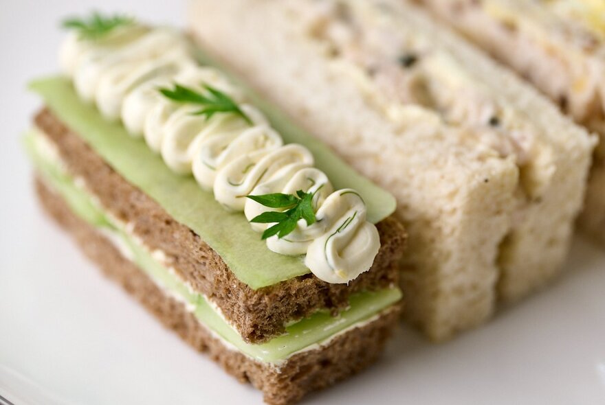 Close up of ribbon sandwiches on a white plate, as part of a high tea selection.