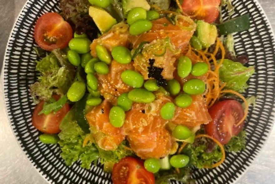 A colourful dish of food on a patterned plate.